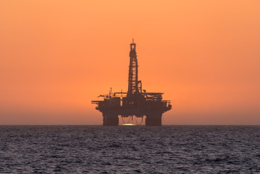 Sun setting behind oil drilling platform at Longbeach in Namibia